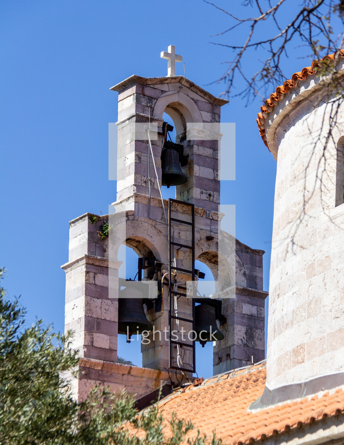 View of the Holy Trinity church bell tower from the narrow streets of Old Town Budva, Montenegro