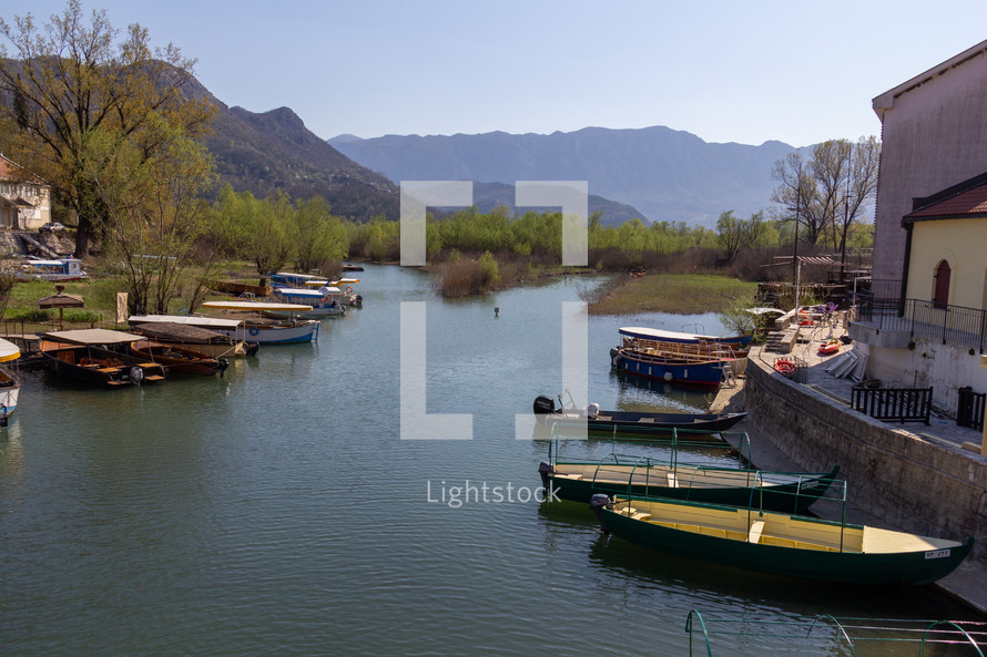 In Virpazar, Montenegro an inlet of Skadar Lake contains multiple tour boats waiting for passengers