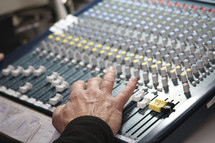 man's hand on a soundboard