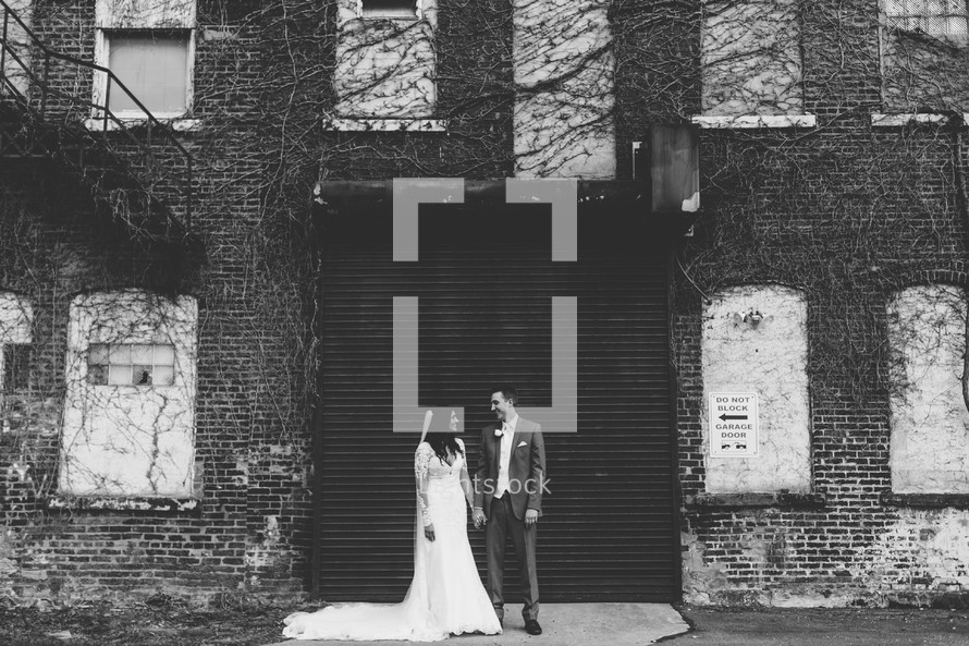 bride and groom in front of an old brick warehouse building 