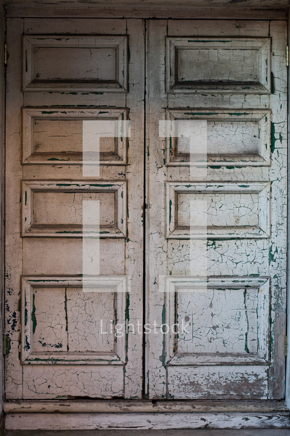 Old door with cracked and peeling white paint