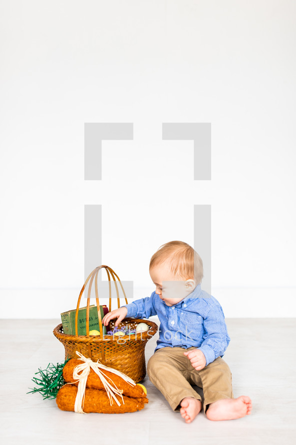a portrait of a toddler boy with an Easter basket 