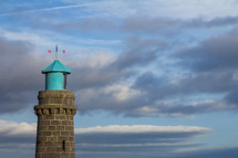 weather vane on a tower - top of Teignmouth lighthouse against a cloudy sky