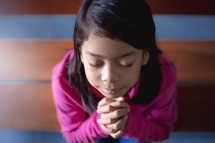 a girl with praying hands 