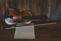 a violin, bow, and sheet music 