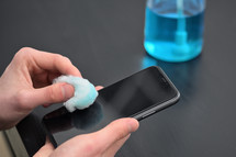 Man Cleaning Smartphone Screen With Alcohol Or Disinfectant