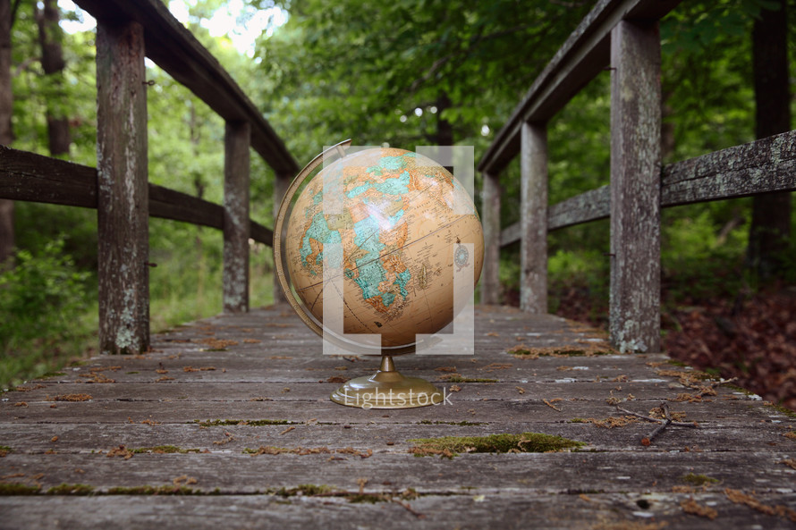 a globe on a weathered wood boardwalk 