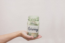hand holding out a giving jar 