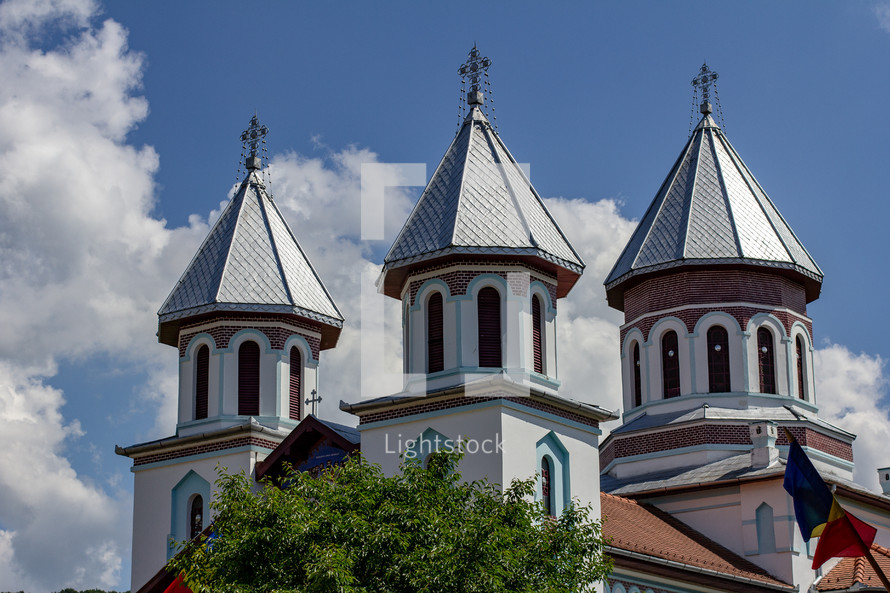 Details of the ornate cupolas on an orthodox church in the village of Blăjel, Romania under a blue sky