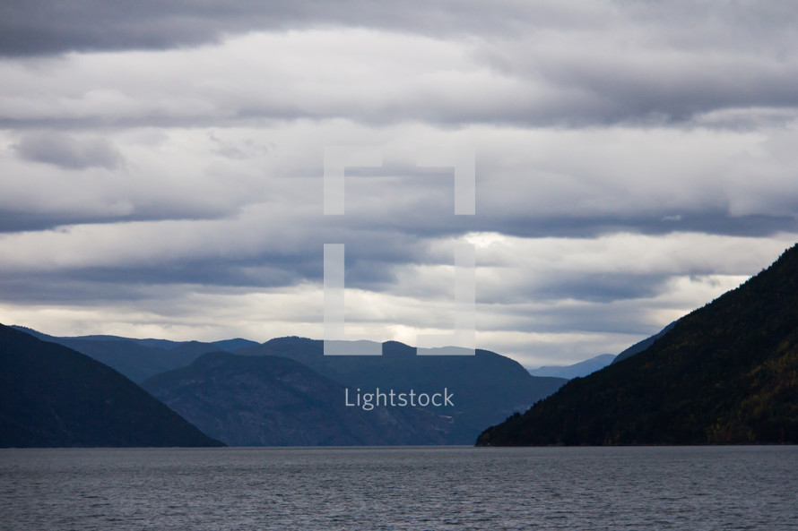Landscape view of Sognefjord and the surrounding mountains in western Norway. Taken from the Flam to Bergen ferry under overcast skies taken at blue hour.