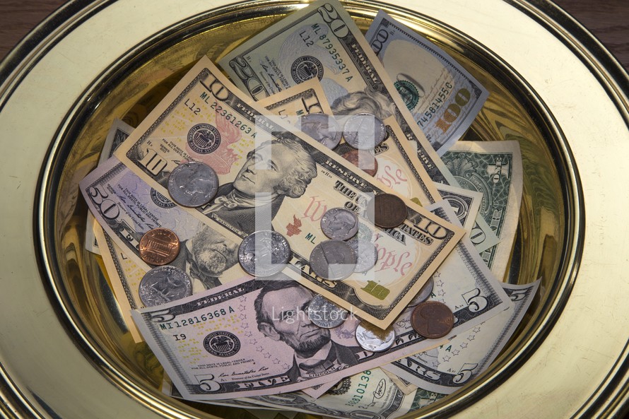 Money in an offering collection plate 