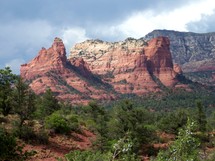Desert mountains, canyons and cliffs. The red rocky cliffs of Sedona, Arizona reach out into a blue overcast sky where rain brings life to the dry desert canyons of Arizona out west.