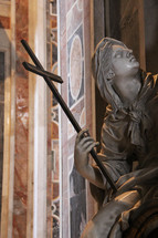 statue holding a cross 