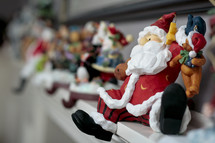 Santa and other Christmas figurines on mantle.