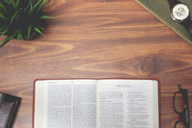 open Bible and reading glasses on a wood table - Hosea 