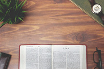 open Bible and reading glasses on a wood table - ezra 