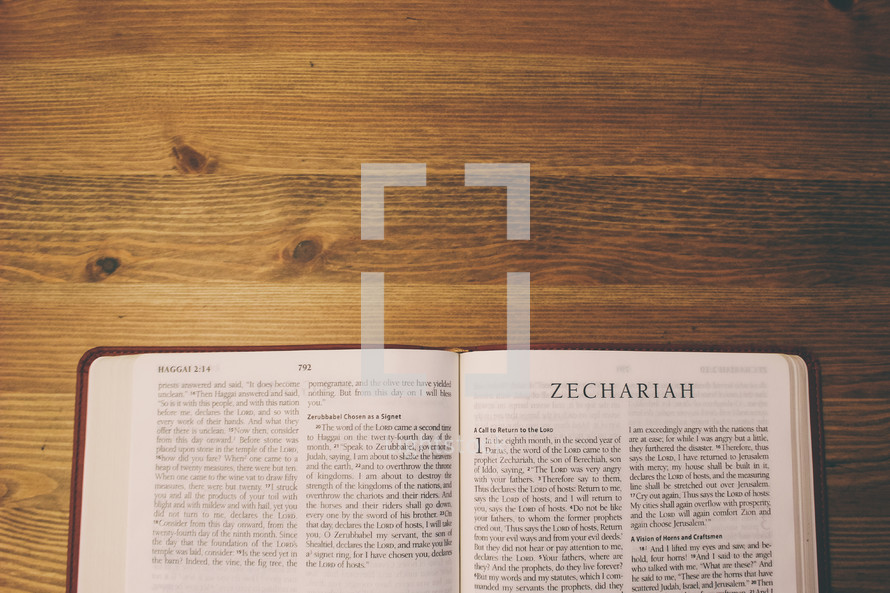 Bible on a wooden table open to the book of Zechariah.
