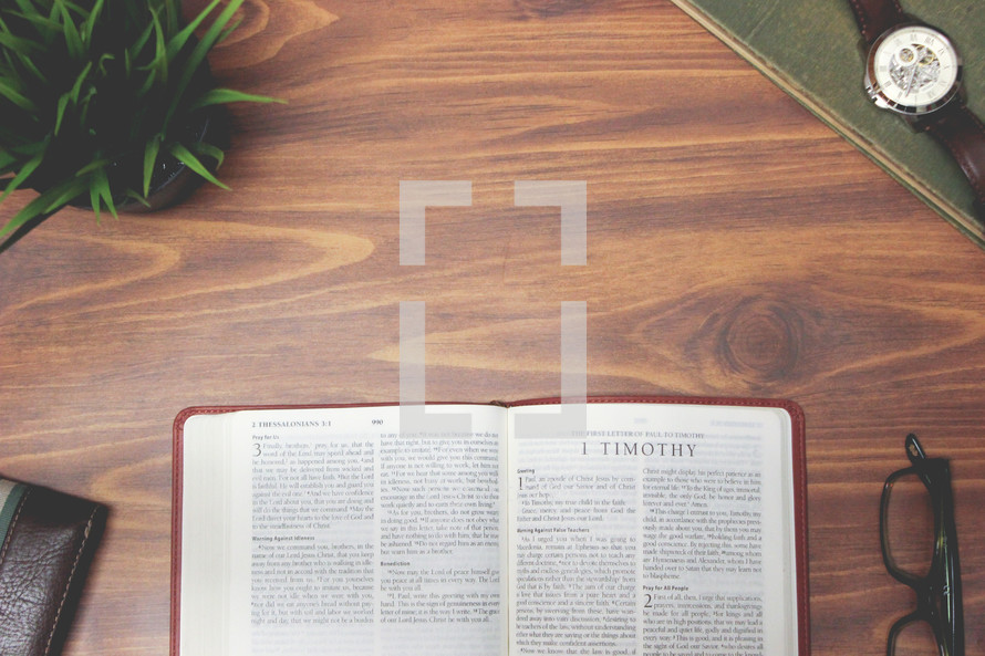 open Bible and reading glasses on a wood table - 1 Timothy 