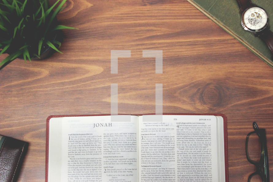 open Bible and reading glasses on a wood table - Jonah