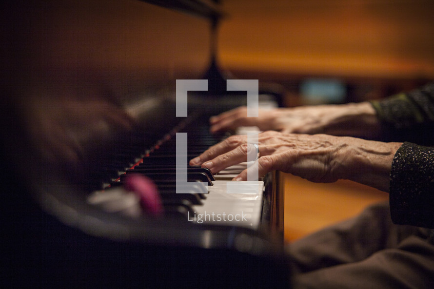 Elderly hands playing the piano.
