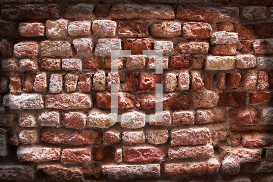 Ancient eroded rustic brick wall 