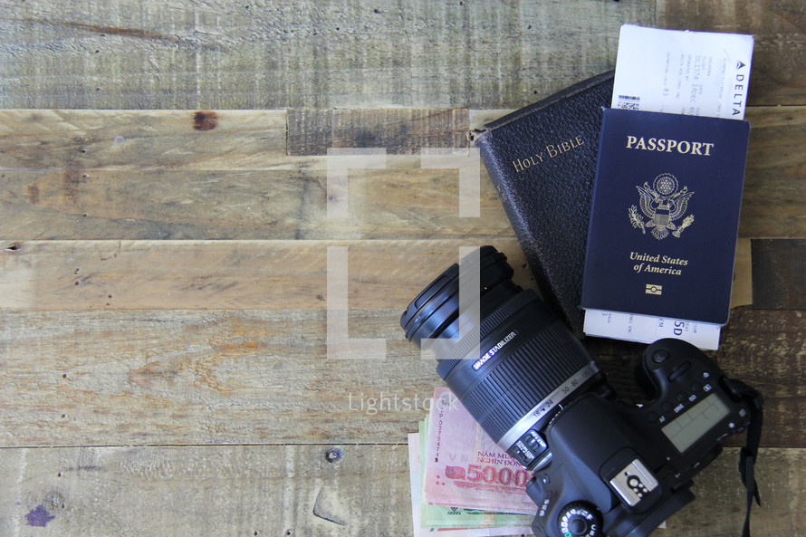 travel, camera, passport, map, book on Central Asia, money, boarding passes, wood floor 