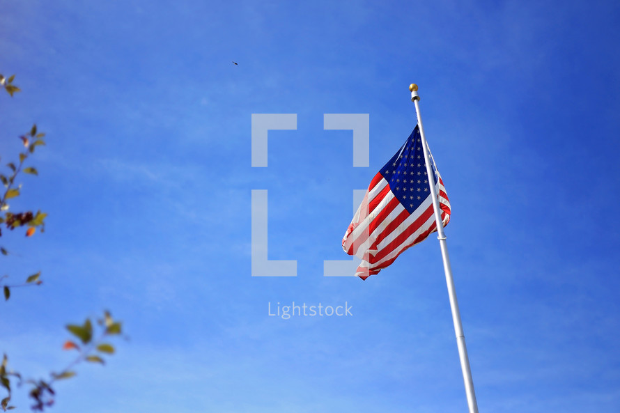 American flag on a flag pole against a blue sky 