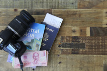 travel, camera, passport, map, book on Central Asia, money, and boarding passes  on a wood floor 