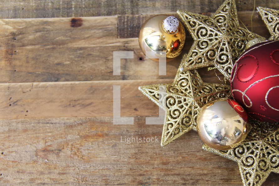 Christmas ornaments, stars and baubles, on a wood floor background 