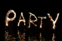 The word 'Party' written in firework sparklers  (by five 'artists' standing in waist high water).