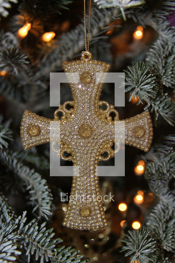 cross ornament hanging on a Christmas tree