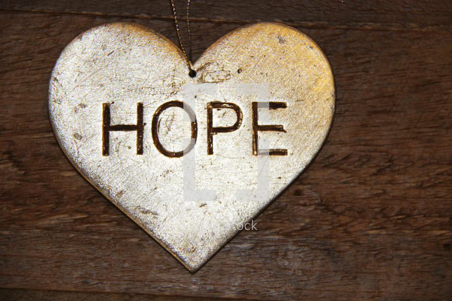 hope on a silver ornament  against a wooden background