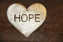 hope on a silver ornament  against a wooden background
