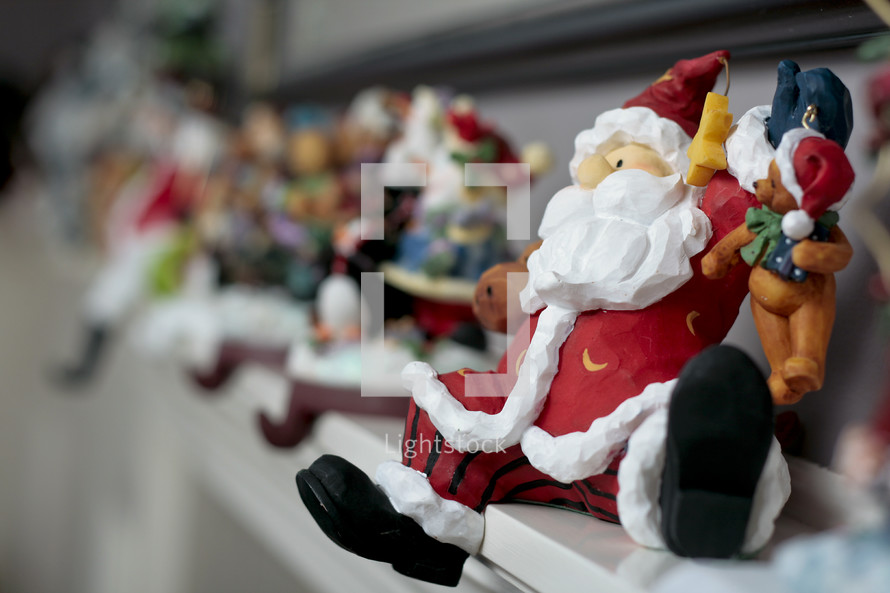 Santa and other Christmas figurines on mantle.