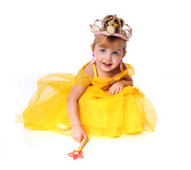 young girl dressed in a yellow princess dress, wearing a crown, carrying a wand