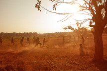 Children playing soccer outside in the dirt in Malawi, Africa. 