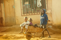 Children in a wheelbarrow in Malawi, Africa. 