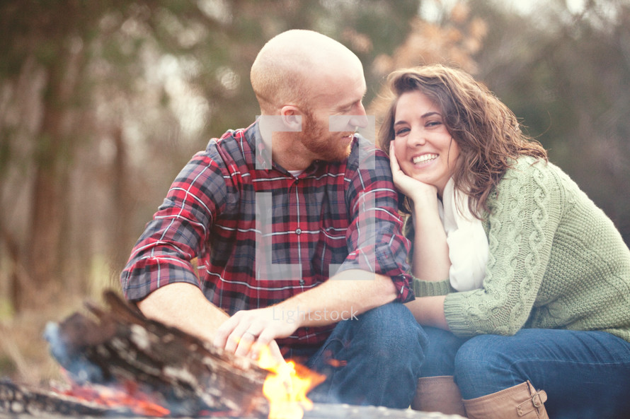 couple sitting by a fire 