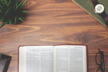 open Bible and reading glasses on a wood table - 1 Thessalonians 