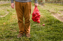 man holding a sack of apples 