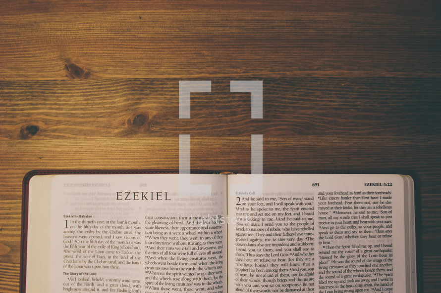 Bible on a wooden table open to the book of Ezekiel.