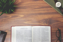 open Bible and reading glasses on a wood table - Ephesians 