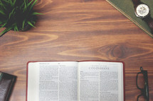 open Bible and reading glasses on a wood table - Colossians 