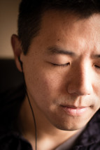 man listening to music with earbuds in 