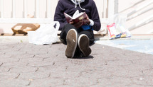 homeless reading a Bible 