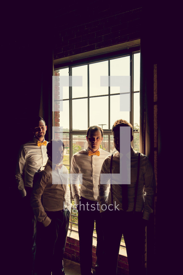 groomsmen standing in front of a window