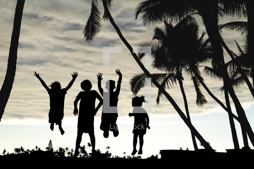 kids jumping and silhouette of palm trees 