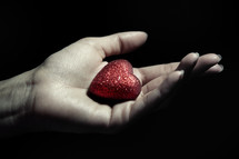 a red heart in a cupped hand 