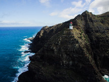 lighthouse on a mountainous shoreline 