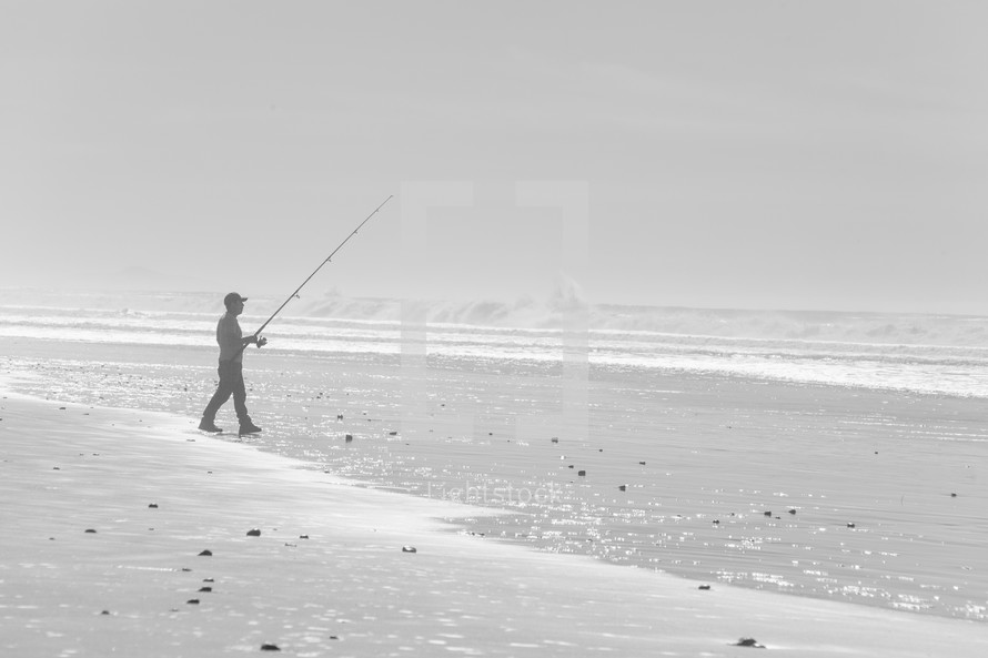 man fishing on a beach 